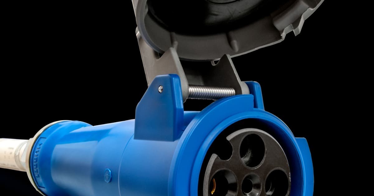 A blue industrial socket connector with an open gray lid and black circular ports attached to a pale cable.