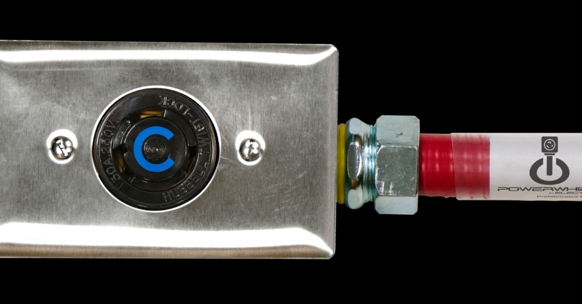 A close-up of a NEMA cable with brushed metal electrical box and a black circular outlet with a red cable.