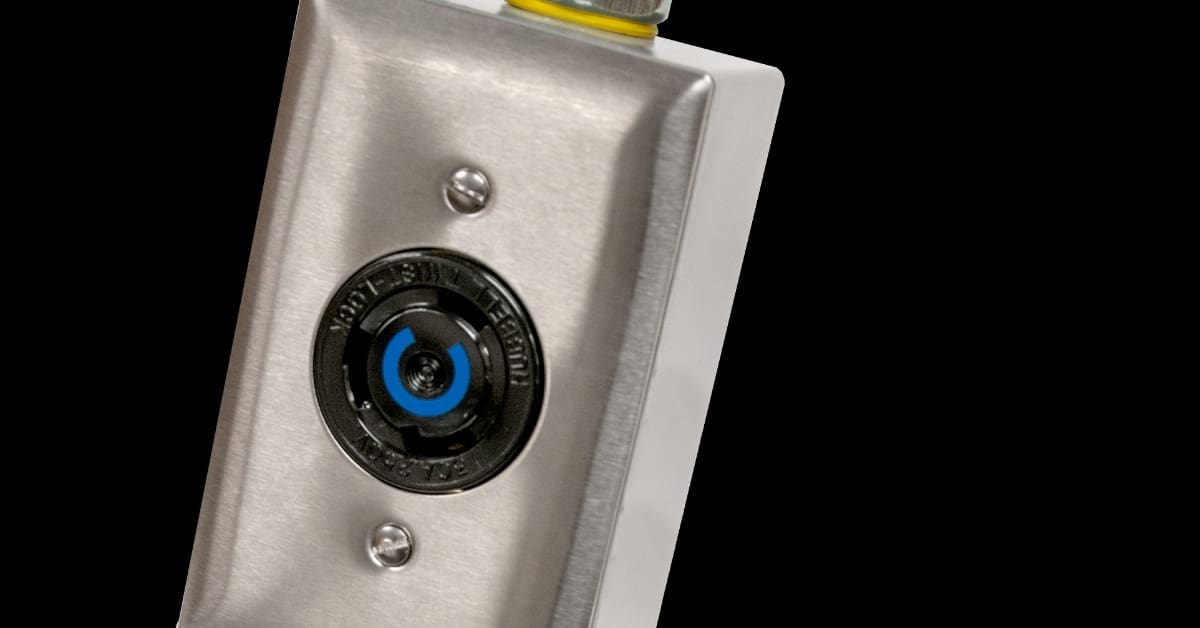 A NEMA cable with a focus on a brushed metal electrical box with two screws and part of a cable on a black background.