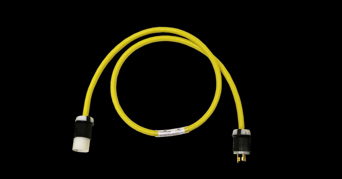A yellow cable forms a loose loop on a black surface, with white and black plug connectors attached at both ends.